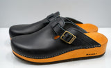 Black buckle clogs with tan platforms, contrast stitching, and antique-gold-tone buckles, side view